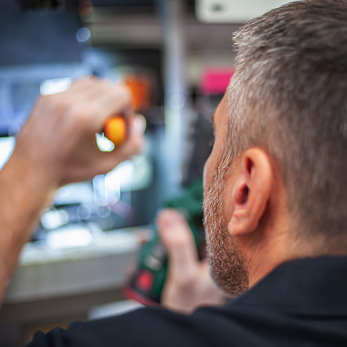 Man using a flashlight to look into technology