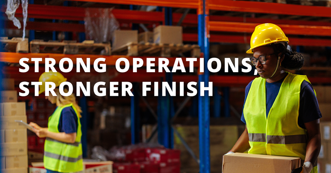 Woman moving boxes in a warehouse setting with the text overlay reading "Strong operations, stronger finish"